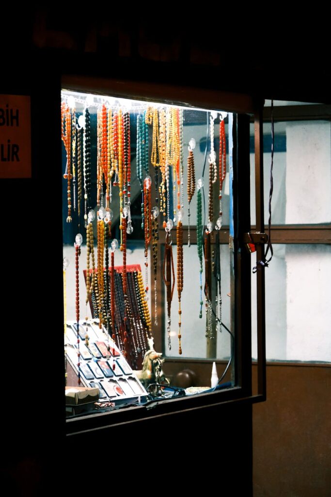 Vibrant bead and accessory shop window illuminated at night with a variety of colors.